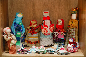 A traditional Russian souvenir is a rag doll. A family of Russian rag dolls on a wooden background