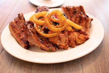 Costillas de cerdo con salsa barbacoa  y aros  de cebolla. Pork ribs with barbecue sauce and onion rings.