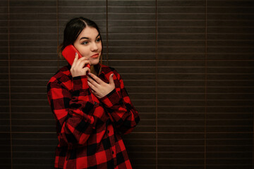 A young pretty girl is talking on the phone. Mobile gadgets and people.