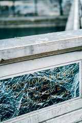 Closeup shot of a stone with an inscription at the entrance of Pont Louis Philippe arch bridge
