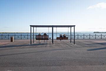 people swing on a swing set on the embankment overlooking the river. rest and walk.