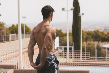 a young athlete stretching his arms after training outdoors.