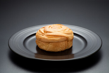Fresh bread in a black plate on black background