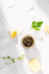 Obraz na płótnie Canvas Appetizers of natural sturgeon black caviar, lemon and parsley