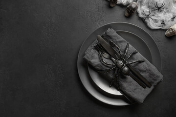 Festive Halloween table setting with horror black decoration, spiders and web. View from above....