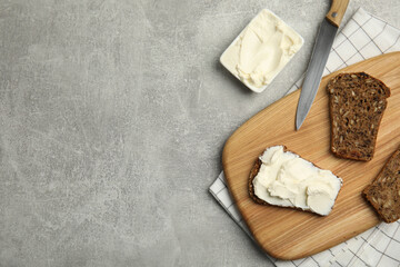 Delicious cream cheese and bread on grey table, flat lay. Space for text