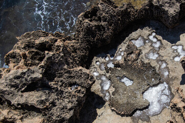 backgrounds and texture on the seashore in stone deposits flooded with water and the remains of sea salt frozen in time