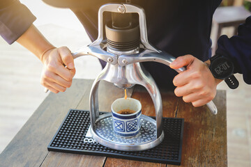 hands showing making espresso coffee ahot from machine in drinking style