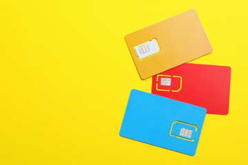 Different SIM cards on yellow background, flat lay. Space for text - obrazy, fototapety, plakaty
