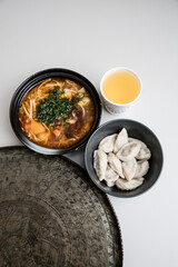 vegetable soup with greens, kurze, pelmeni, lemon orange juice and silver plate on the white background