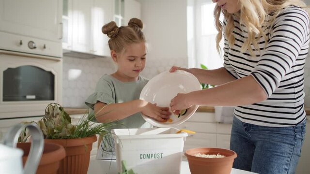 Video of mother and daughter composting organic garbage. Shot with RED helium camera in 8K