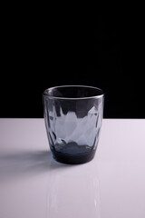 black glass beaker on a black-white background. Minimalist