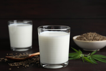 Glass of fresh hemp milk on wooden table
