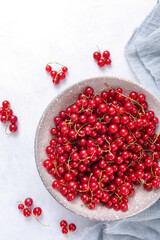 Fresh red currant in wooden bowl on grey table