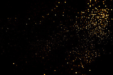Golden abstract bokeh on black background.