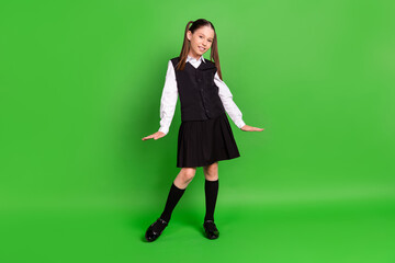 Photo of adorable cute schoolgirl dressed white black uniform smiling walking isolated green color...