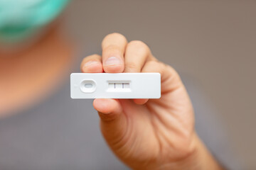 Man hand holding Covid 19 positive result self test.