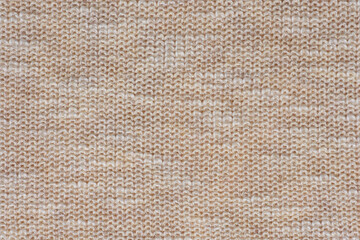 Macro view synthetic beige knitted fabric close up. Knitting pattern of wool. Knitting Horizontal orientation beige wool texture background.	