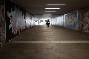 Motorradfahrer in bunten Graffiti Tunnel 