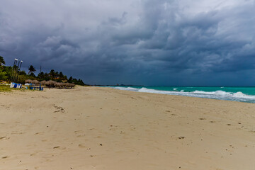 blue clouds and big waves during storm, empty beach