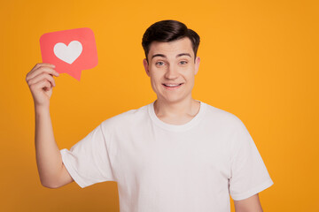 Portrait of cheerful friendly guy hold notification like card on yellow background