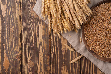 Wheat on the Wooden Table. Sheaf of Wheat over Wood Background. Harvest organic concept.