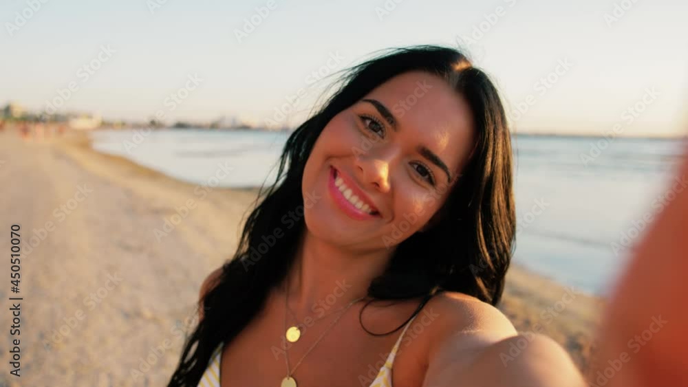 Wall mural people, summer and swimwear concept - happy smiling young woman in bikini swimsuit taking selfie and