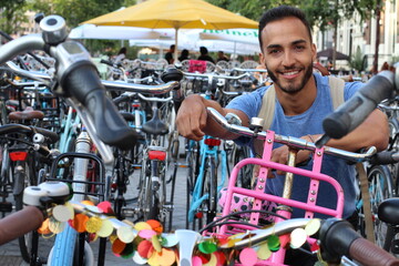 Fototapeta na wymiar Young ethnic adult in modern bicycle parking lot 