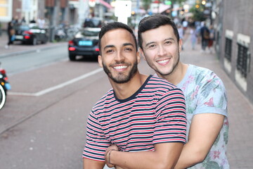 Two cute guys showing affection outdoors 