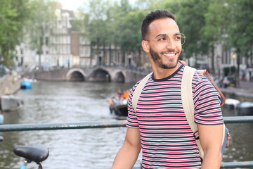 Young mixed race man enjoying a European cityscape view with a river
