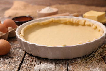 raw puff pastry dough on wood background