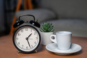 Fototapeta na wymiar good morning concept - modern alarm clock and houseplant on bedside table