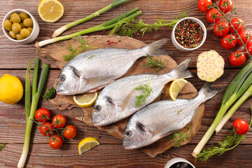raw fish with ingredient on wooden board