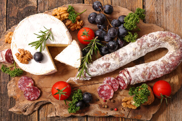 camembert and sausage on wooden board