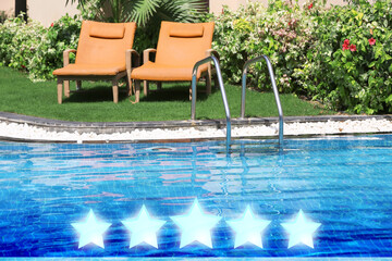 Sunbeds near swimming pool at five star hotel