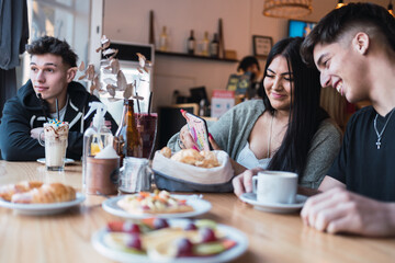 A group of friends enjoying a delicious snack in a cafe bar.