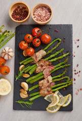 Asparagus baked with bacon and spices. healthy food. top view. homemade prosciutto wrapped asparagus with salt and pepper. ketogenic diet. diet menu. Top view, overhead, banner.