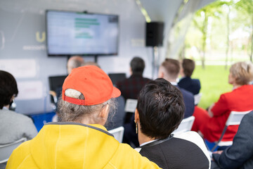 Participants of open air conference listening to speaker