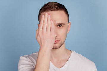 Photo of young handsome man palm hide eye look watch vision oculist check isolated blue color background