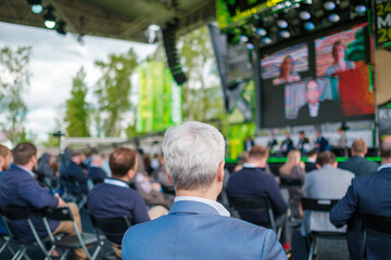 Participants of open air conference listening to speaker