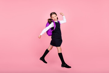 Full size profile side photo of young school girl happy positive smile go walk jump lesson isolated over pink color background