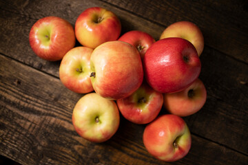 Red and yellow ripe apples lying on a wooden table.Fresh bright fruits and berries on a wooden background.