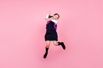 Fototapeta na wymiar Full length body size photo schoolgirl jumping with rucksack raising hand isolated pastel pink color background