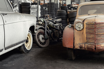 Many rusty abandoned forgotten antique oldtimer old car and motorcycles at junkyard factory storage...