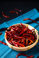 Food concept Dried Red Hot Chili, Chile peppers in bamboo wicker tray on black background with copy...