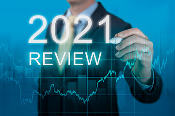 businessman writes 2021 review words. businessman writes 2021 results on virtual screen. economic...