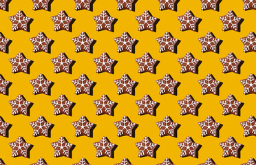 Pattern of christmas cookie stars on yellow pastel background