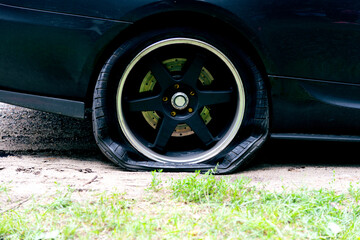 Punctured wheel of a modern car on the road. Car tire puncture