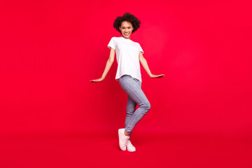 Fototapeta na wymiar Full length body size photo smiling curly woman in casual clothes isolated bright red color background