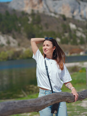 Young woman enjoying beauty of nature mountain lake. Adventure travel in Europe. Sunny summer day